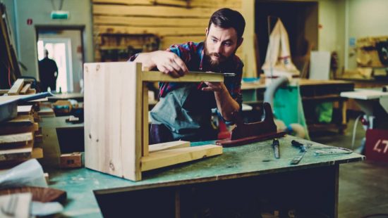 hombre muestra como hacer un taburete de madera